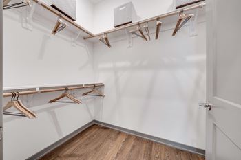 A white closet with wooden hangers and a white door at The Boardwalk at Tradition, Port St Lucie, Florida